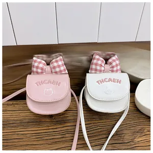 Detail of kids pink and white crossbody bags with cat embroidery and plaid bow decoration