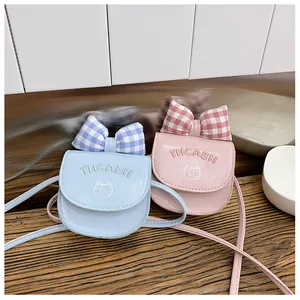 Close-up of mini crossbody bags with bowknot, cat embroidery, and texture details