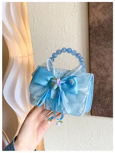Detail of light blue lace girl handbag with satin bow and blue beaded handle