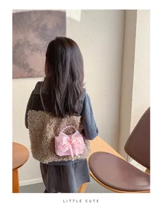 Détail du sac à main en dentelle rose avec poignée en perles et nœud pour petites filles