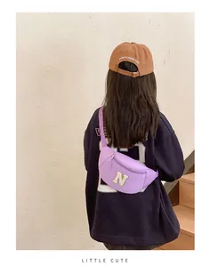 Detail of lavender kids fanny pack with N letter patch worn as a cross-body bag
