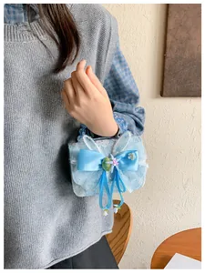 Detail of light blue girls handbag with lace overlay and large silk bow decoration