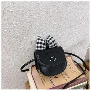 Detail of a mini black PU crossbody bag featuring a large checkered bow and cat embroidery