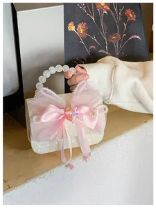 Detailed shot of white lace texture with sequins and pink bow on elegant kids mini handbag