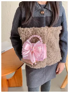 Sac à main rose pailleté pour fille avec anse en perles et nœud en situation
