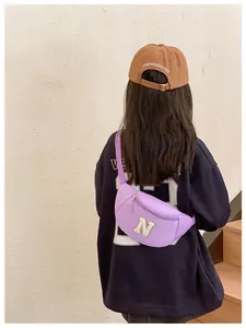 Detail of lavender canvas kids waist bag featuring a white towel embroidered letter N