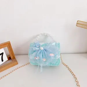 Close-up of light blue lace kids handbag with pearl handle, mesh bow and starfish detail