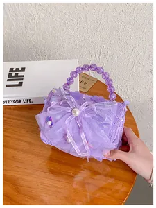 Détail du sac à main violet à paillettes avec nœud en résille et anse perlée