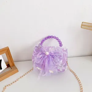 Detail of lavender princess bag with white lace overlay and large mesh bow with pearl