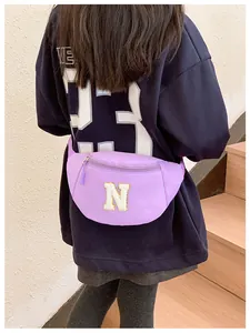 Rear view of a child wearing the purple lettered waist bag on an outdoor staircase