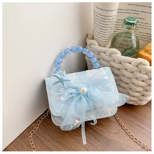 Detail of light blue lace kids bag with mesh bow, pearl center, and beaded handle