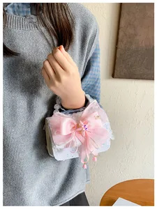 Détail de sequins, nœud en soie rose et poignée en perles de ce sac princesse élégant
