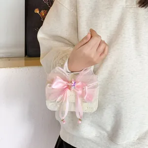 Girl's lace handbag with pink bow, starfish charm, and pearl handle over a knit sweater