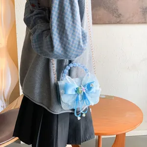 Girl's blue lace shoulder bag with bow and starfish details shown on model