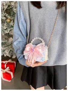 Détail d'un sac à main pailleté pour filles avec nœud rose et poignée en perles