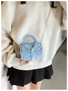 Détail sac à main bleu clair pour fille avec paillettes nœud organza et perles