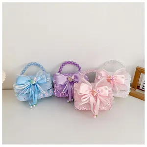 Détail de sacs à main pailletés pour filles avec nœuds géants et anses en perles pastel