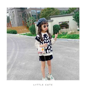 Detailed view of pink rabbit crossbody bag paired with polka dot vest and beret