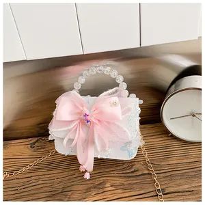 Détail du nœud en satin rose et sequins papillon sur le sac perlé pour petite fille