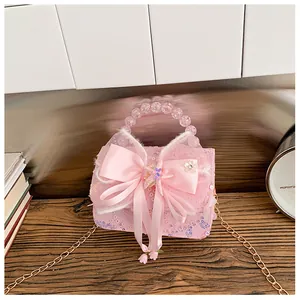 Détail du sac à main rose pour fille avec paillettes, nœud satiné et perles de nacre