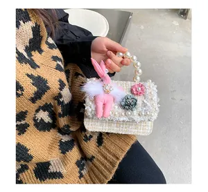 Détail du mini sac tissé avec poignée en perles et décoration de lapin en peluche