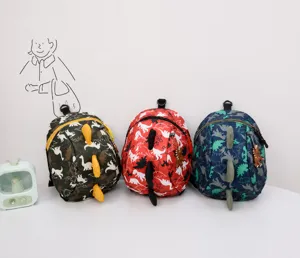 Detailed view of kids dinosaur backpacks in green, red, and navy with 3D spine accents