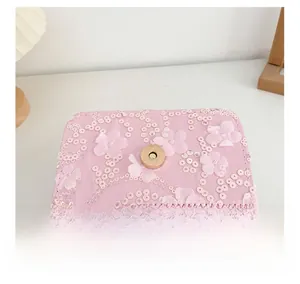 Détails du sac rose à paillettes avec décor floral et fermoir magnétique