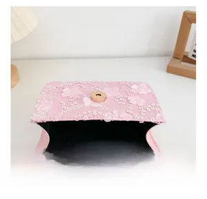 Détail de la doublure et du fermoir magnétique du sac à bandoulière rose pailleté