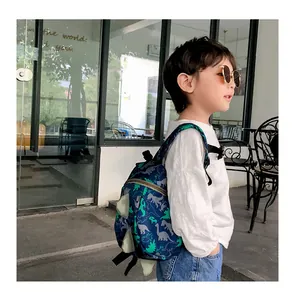 Detail view of navy dinosaur backpack with 3D green spine plates and chest strap
