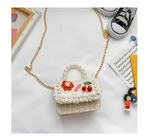 Détail du mini sac en tweed avec poignée en perles et décorations florales