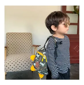 Detail of green dinosaur toddler backpack with 3D yellow scales and zipper closure