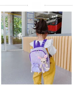 Close-up of kids purple checkerboard backpack with plush bunny and adjustable straps