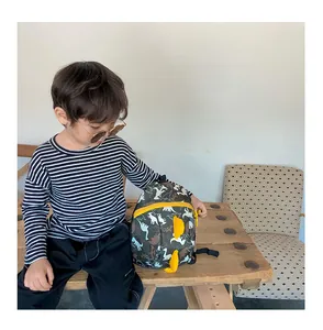 Toddler backpack featuring colorful dinosaur prints and 3D dorsal fins on side view
