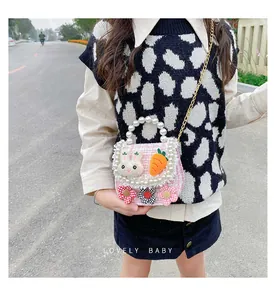 Detail of pink tweed girl's mini bag with pearl handle and cute rabbit patches