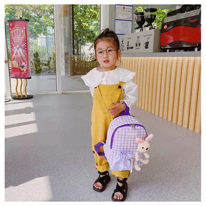 Detail of lavender checkered toddler backpack featuring a cute plush bunny charm