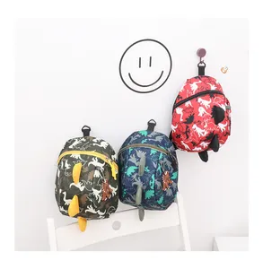 Detailed view of dinosaur mini backpacks in red and navy with 3D fins and matching charms