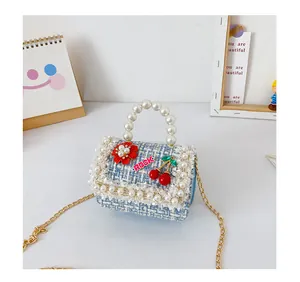 Détail du sac à main en tweed bleu pour filles avec poignée perle et dentelle