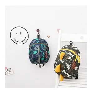 Detailed view of kids cartoon dinosaur backpacks in navy and camo colors for school