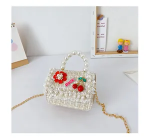 Détail de mini sac en tweed pour fille avec poignée perle et pendentif cerise