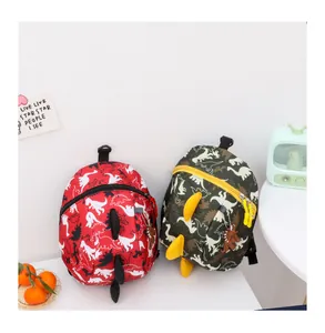 Detail of red and camo dinosaur backpacks with 3D fins and waterproof nylon fabric