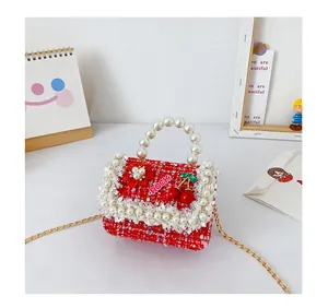Détail du mini sac fille en tweed rouge avec poignée perle et breloques cerise