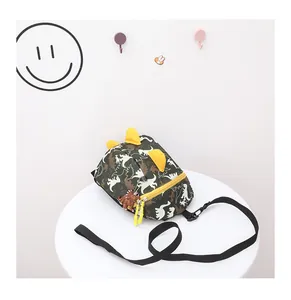 Close-up of children's camo dinosaur crossbody bag with yellow zipper and 3D spikes