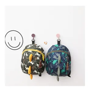 Detail of cartoon dinosaur backpacks in green and navy with 3D fins for kids