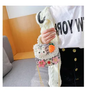 Detail of kids crossbody bag featuring plush bunny, pearls, and colorful fabric flowers