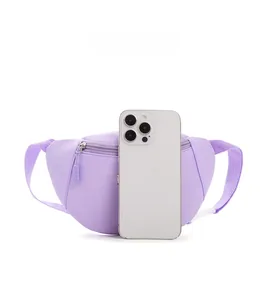 Close-up of light purple kids chest bag with adjustable strap next to phone for scale