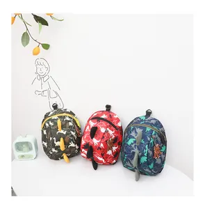 Three children dinosaur backpacks in green, red, and navy with 3D fins and dinosaur prints