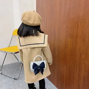 Kids plaid crossbody bag with large bow, pearl handle and gold chain strap on model