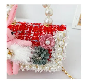 Détail du sac en tweed rouge pour fille avec perles et breloque lapin en peluche