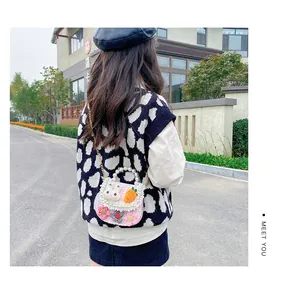 Pink plaid girls crossbody bag with pearl handle and plush bunny detail on outdoor model