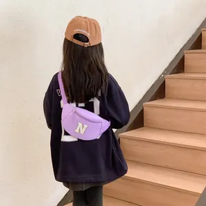Girl wearing a light purple canvas kids chest bag with large white N letter patch